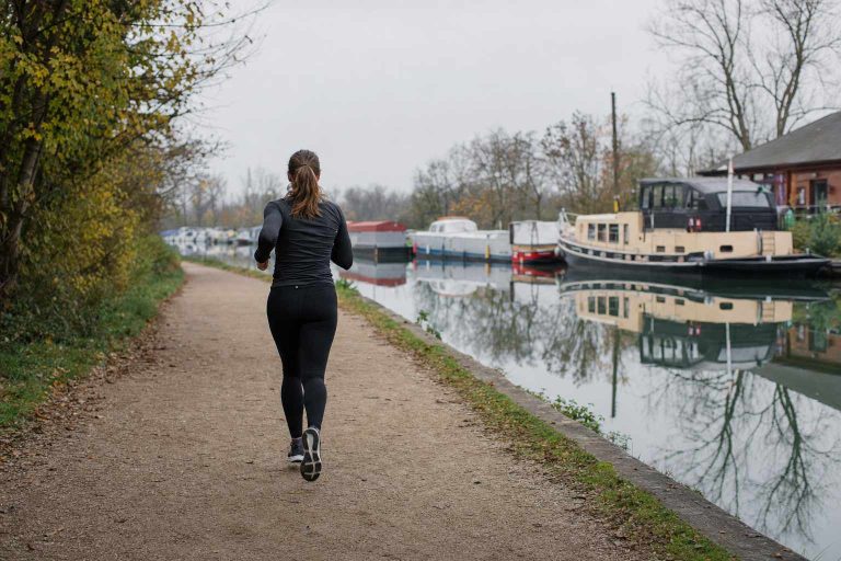 A runner on a canal towpath on an ordinary daily run
