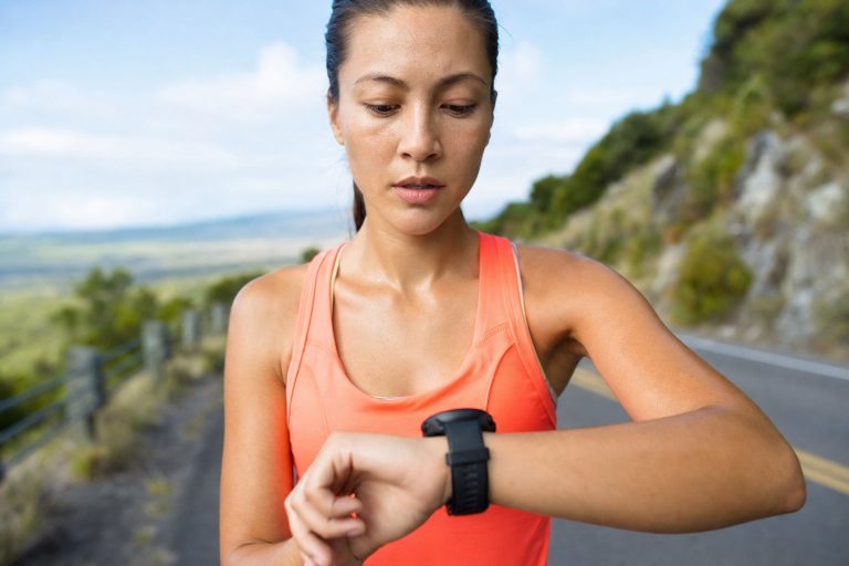 A runner checking pace on a sports watch mid run